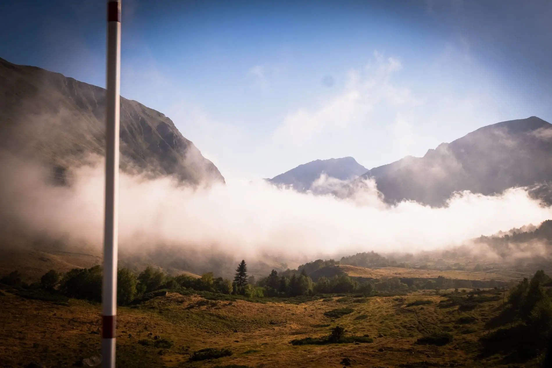 Morning mist rolling through a green valley in the Andorran Pyrenees